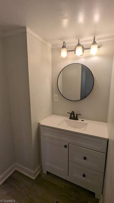 bathroom featuring ornamental molding, hardwood / wood-style flooring, and vanity