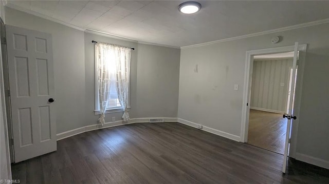 empty room featuring dark hardwood / wood-style floors and crown molding