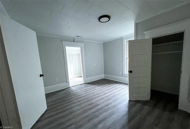 unfurnished bedroom with dark hardwood / wood-style floors and a closet