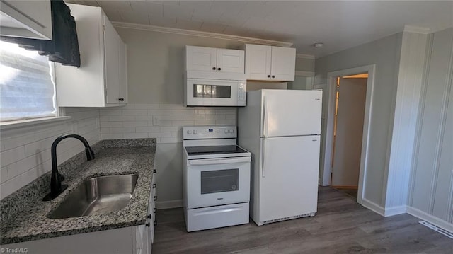 kitchen featuring white cabinetry, white appliances, dark stone counters, hardwood / wood-style floors, and sink