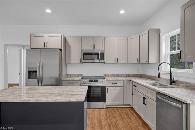 kitchen featuring light hardwood / wood-style floors, appliances with stainless steel finishes, gray cabinets, and sink