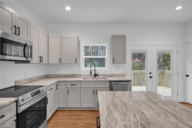 kitchen with french doors, plenty of natural light, sink, and appliances with stainless steel finishes