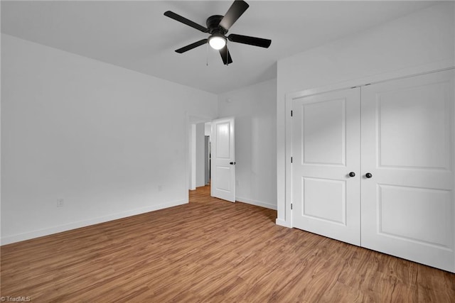 unfurnished bedroom featuring light hardwood / wood-style floors, ceiling fan, and a closet