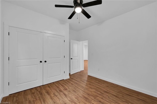 unfurnished bedroom featuring hardwood / wood-style floors, ceiling fan, and a closet