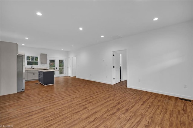 unfurnished living room with light hardwood / wood-style flooring and sink