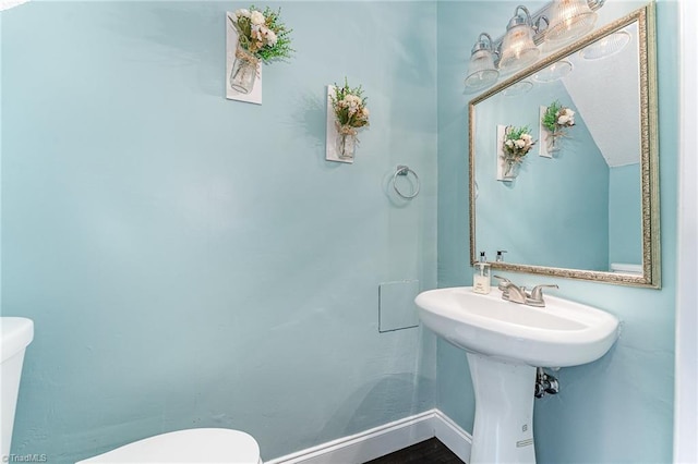 half bath with toilet and baseboards