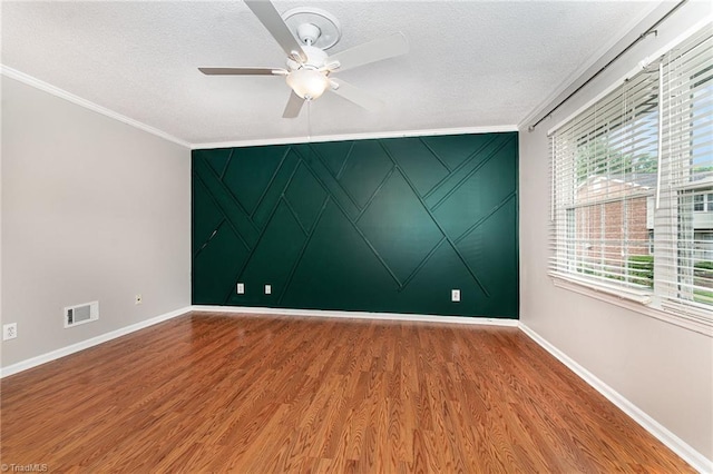 empty room featuring baseboards, ornamental molding, a textured ceiling, wood finished floors, and a ceiling fan