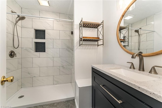 full bath with a textured ceiling, a stall shower, and vanity