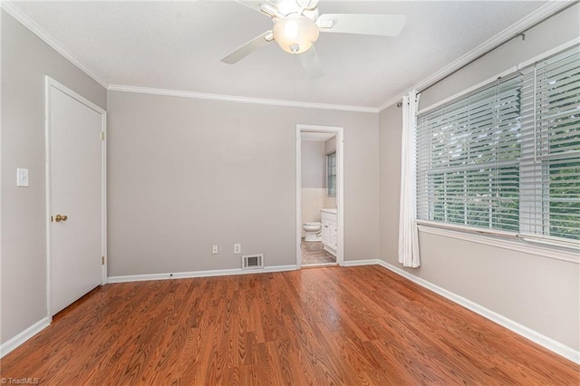 spare room with ornamental molding, a ceiling fan, wood finished floors, and baseboards