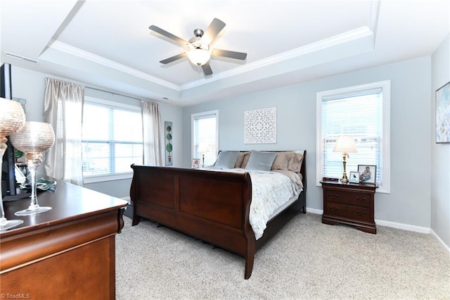 bedroom featuring ceiling fan, light colored carpet, ornamental molding, and a raised ceiling