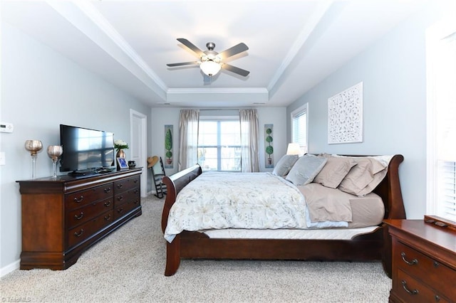 carpeted bedroom featuring crown molding, a tray ceiling, and ceiling fan