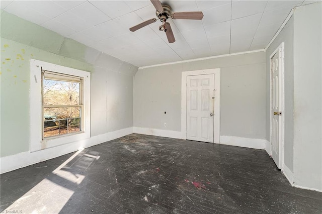 unfurnished room with ceiling fan and crown molding