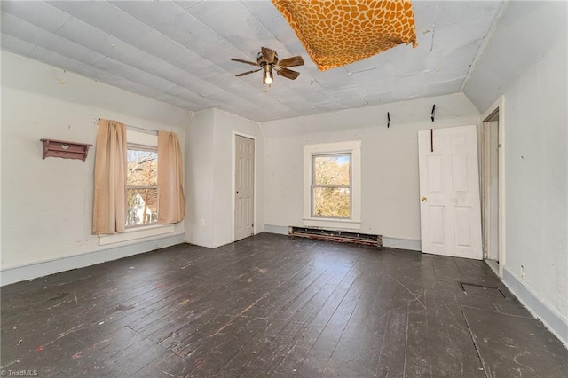 unfurnished room featuring lofted ceiling, ceiling fan, a baseboard radiator, and dark hardwood / wood-style floors