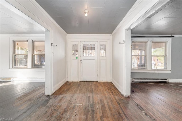 entryway featuring dark hardwood / wood-style floors, baseboard heating, and ornamental molding