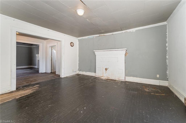 spare room featuring ornamental molding and dark wood-type flooring