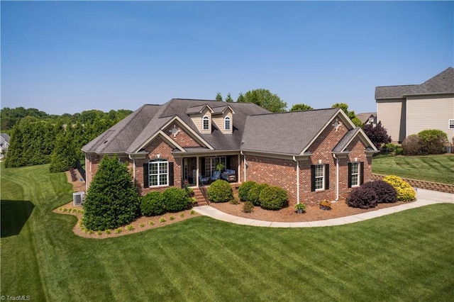 view of front of house featuring brick siding, a front yard, and covered porch