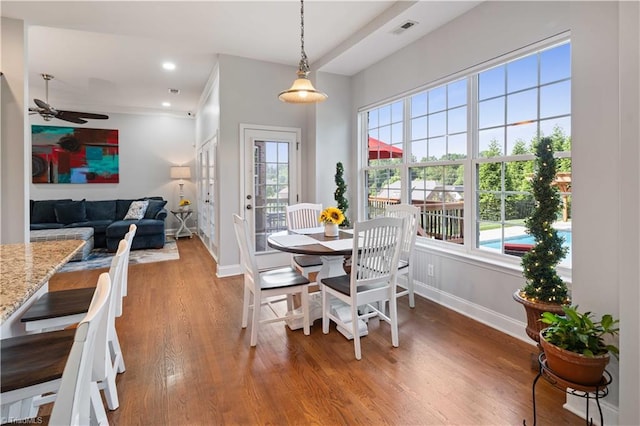dining space featuring baseboards, a ceiling fan, and wood finished floors