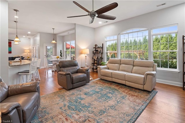 living area with wood finished floors, ceiling fan, recessed lighting, and baseboards