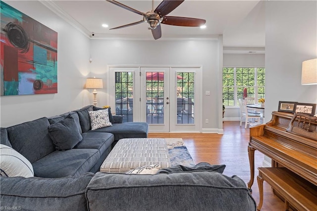 living area with a ceiling fan, wood finished floors, crown molding, recessed lighting, and french doors