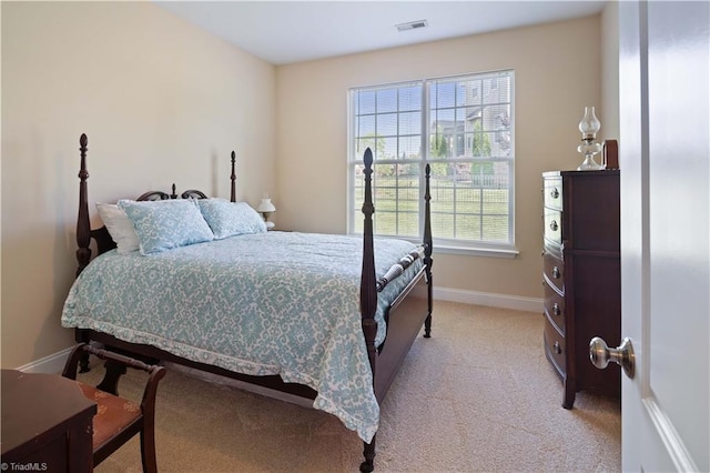 bedroom with baseboards and light carpet