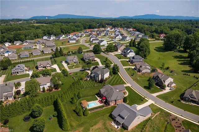 aerial view of property and surrounding area featuring mountains and nearby suburban area