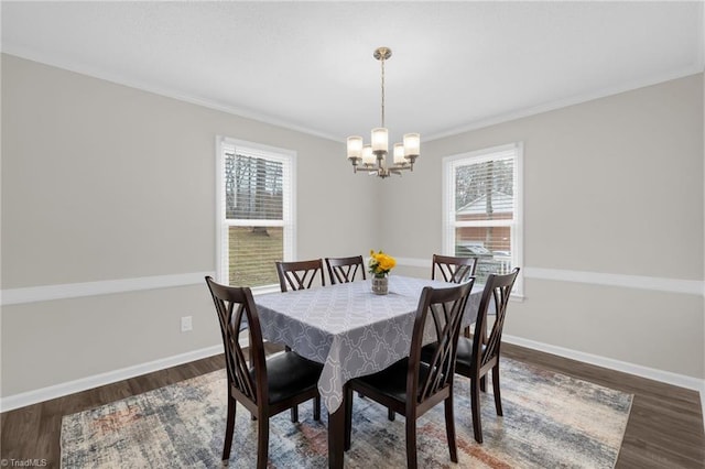 dining space featuring ornamental molding, dark hardwood / wood-style floors, a wealth of natural light, and an inviting chandelier