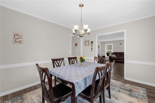 dining room featuring crown molding, dark hardwood / wood-style floors, and an inviting chandelier