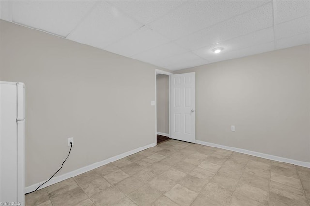 unfurnished room featuring a drop ceiling