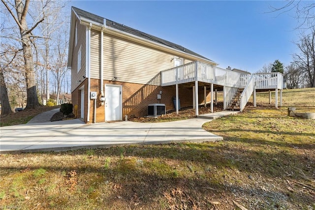 rear view of property with a yard, central AC, and a deck