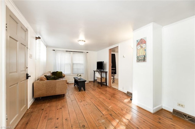 living room featuring light wood-style flooring, visible vents, and baseboards