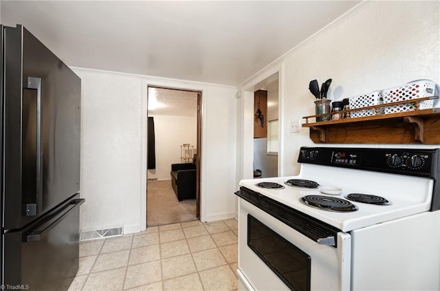 kitchen with freestanding refrigerator, electric stove, and visible vents