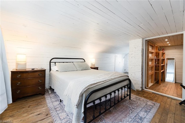 bedroom featuring hardwood / wood-style floors, wood walls, and wood ceiling