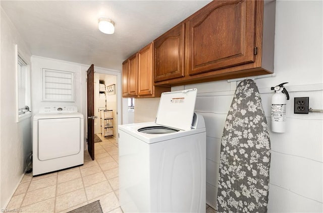 washroom featuring cabinet space and washer and clothes dryer