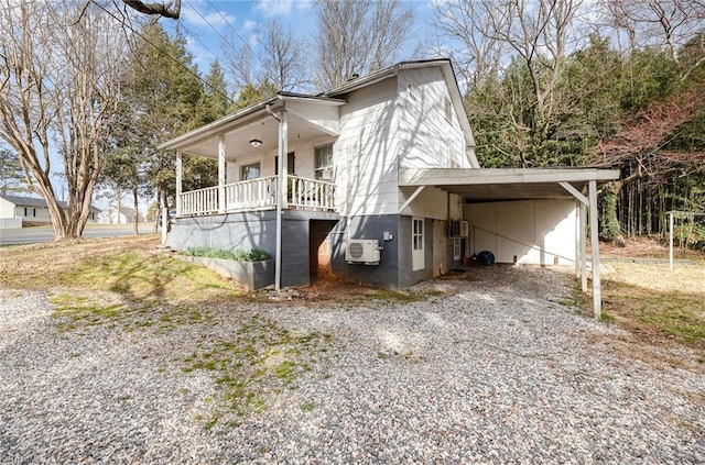 view of side of home with gravel driveway and an attached carport