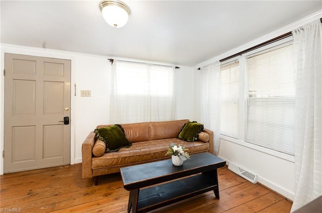 living room featuring light wood-style flooring, visible vents, and baseboards