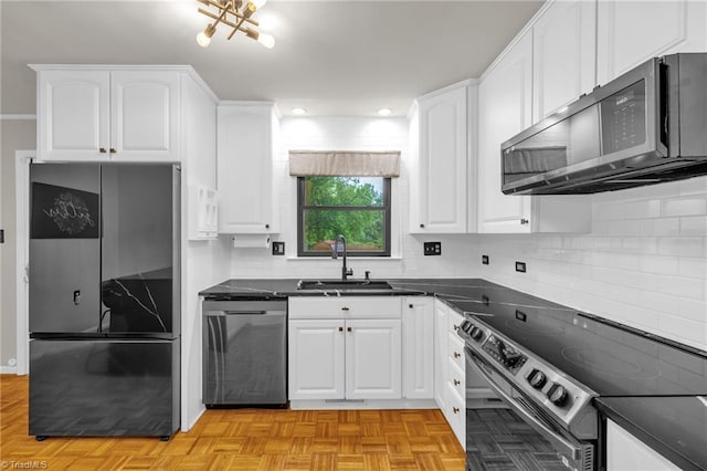 1508 Lafayette Ct, Greensboro, NC 27408 - kitchen featuring stainless steel appliances, a sink, dark countertops, white cabinets, and tasteful backsplash