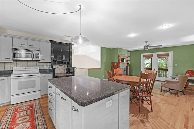 1134 Edwards Farm Rd, King, NC 27021 - kitchen featuring electric range, stainless steel microwave, light wood-type flooring, a ceiling fan, and backsplash