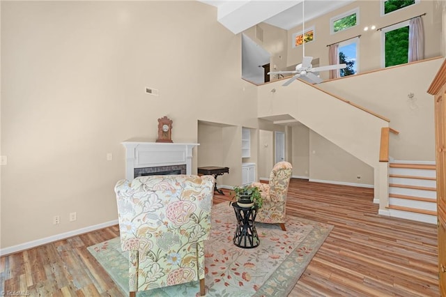 1134 Edwards Farm Rd, King, NC 27021 - living room featuring stairs, ceiling fan, baseboards, wood finished floors, and a high ceiling