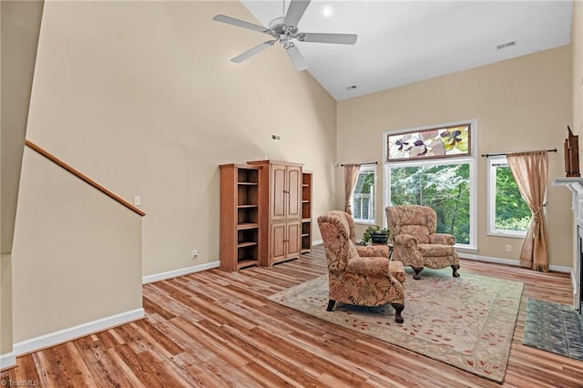 1134 Edwards Farm Rd, King, NC 27021 - living area featuring a high ceiling, wood finished floors, baseboards, ceiling fan, and a fireplace with flush hearth