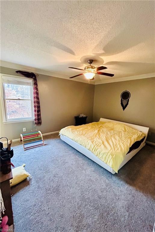 carpeted bedroom with a textured ceiling and ceiling fan