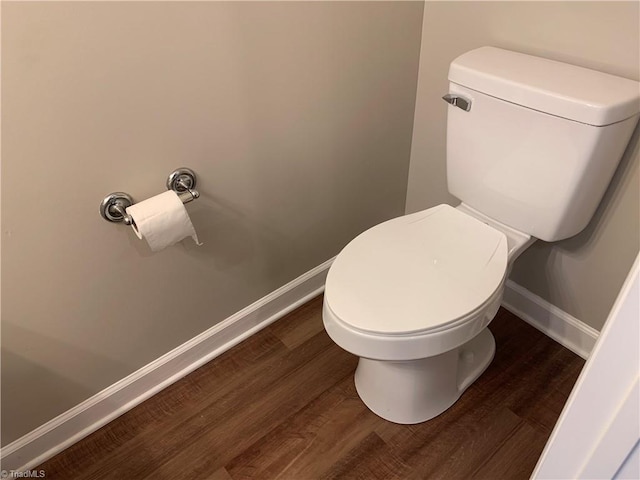 bathroom with baseboards, toilet, and wood finished floors