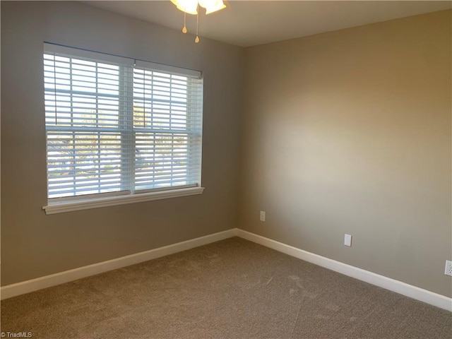 carpeted empty room with baseboards