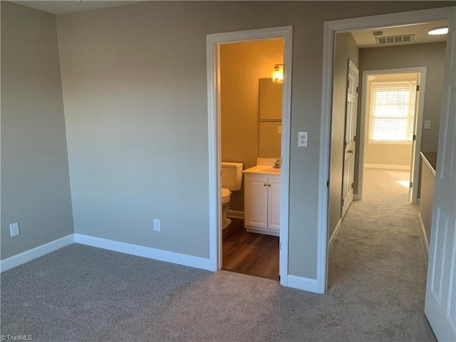 unfurnished bedroom featuring baseboards, carpet, visible vents, and a sink