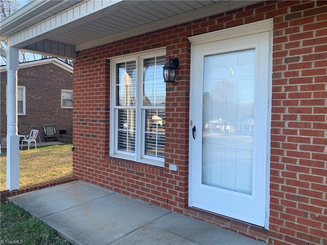 doorway to property featuring brick siding