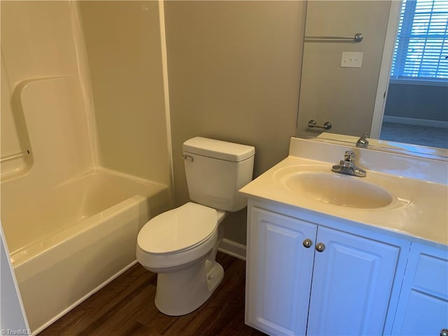 bathroom with tub / shower combination, toilet, vanity, and wood finished floors