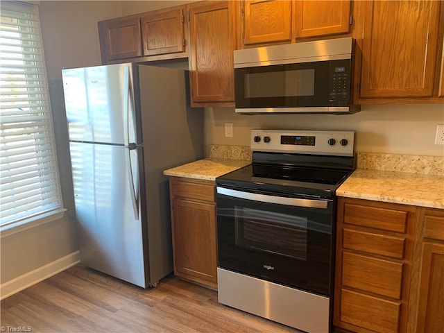 kitchen featuring plenty of natural light, appliances with stainless steel finishes, and brown cabinetry