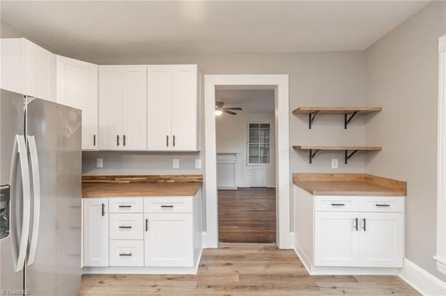 kitchen featuring white cabinetry, stainless steel fridge with ice dispenser, light wood-type flooring, and butcher block countertops