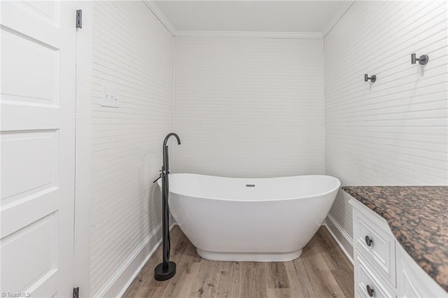 bathroom with crown molding, vanity, hardwood / wood-style floors, and a tub