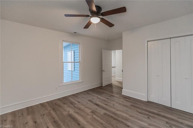 unfurnished bedroom featuring light hardwood / wood-style floors, a closet, and ceiling fan