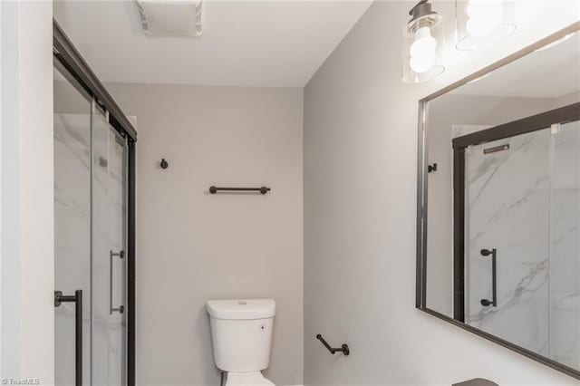 bathroom featuring toilet and an enclosed shower